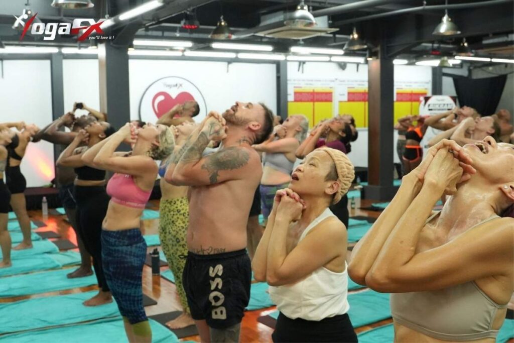 Students opening class with standing deep breathing pranayama at the YogaFX studio in Seminyak, the coastal base for a split Ubud and coast stay